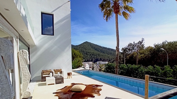 A modern pool area with a clear view of a mountain and palm trees. - My Rental Homes - Villa Seahorse private pool and air conditioning (Cala Llonga)