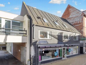 A building with a modern design, featuring a prominent sloped roof and large windows.