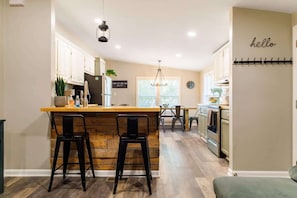 Enjoy meals in the kitchen with a central island and dining area featuring a table and chairs.