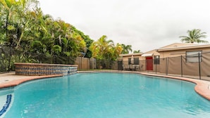 A swimming pool with a tiled edge, surrounded by a fence and palm trees. - 5BR Family Oasis w/ Pool, Near Beach & Downtown (Hollywood)