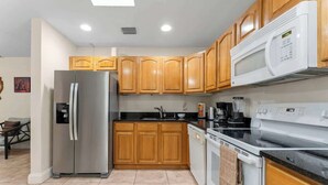 A kitchen with wooden cabinets, a stainless steel refrigerator, a microwave, a stove, and a dishwasher. - 5BR Family Oasis w/ Pool, Near Beach & Downtown (Hollywood)