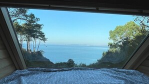 A bedroom with a view of the sea through a window. - Magnificent house sea view- Jacuzzi- 2Ha land- GR34 (Poullan-sur-Mer)