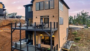A modern two-story house with a balcony, large windows, and a visible garage.