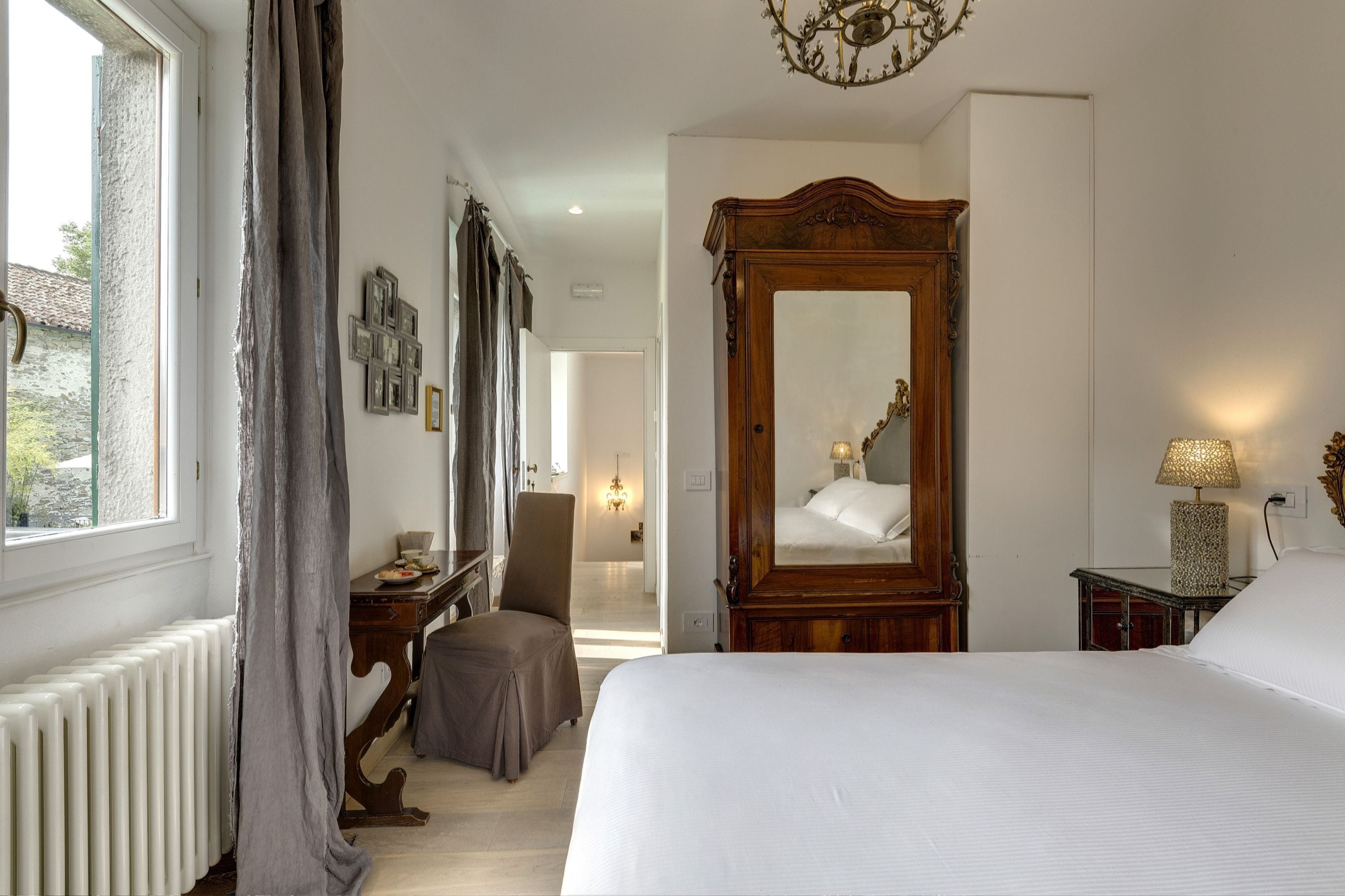 Une chambre à coucher avec un grand lit, une armoire en bois, un bureau et une chaise.