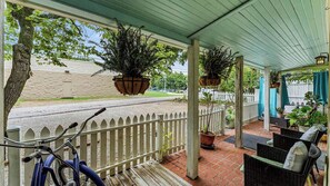 A covered porch with a white picket fence, potted plants, and outdoor furniture. - Hot Tub, Grill, Patio, Parking, 5 Mins downtown (Eureka Springs)