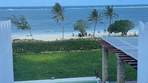 Et poolområde med udsigt til strand og hav.