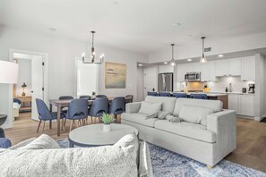 Un salon moderne avec un canapé, une table basse et un coin repas.