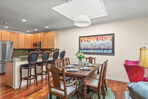 Cocina moderna con armarios de madera, una isla central y taburetes de bar.