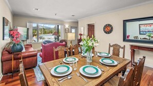 A dining area with a wooden table set for four, surrounded by wooden chairs. - Pet-Friendly Top-Floor Downtown Carbondale Retreat with A/C, Views & Walkable Main Street (Carbondale)