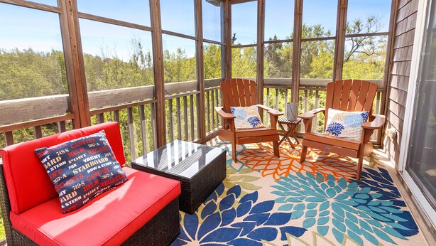 A covered outdoor seating area with wicker furniture and a colorful rug. - Prime Location, Short Walk To The Beach, Water Views, Sun Deck (Rodanthe)