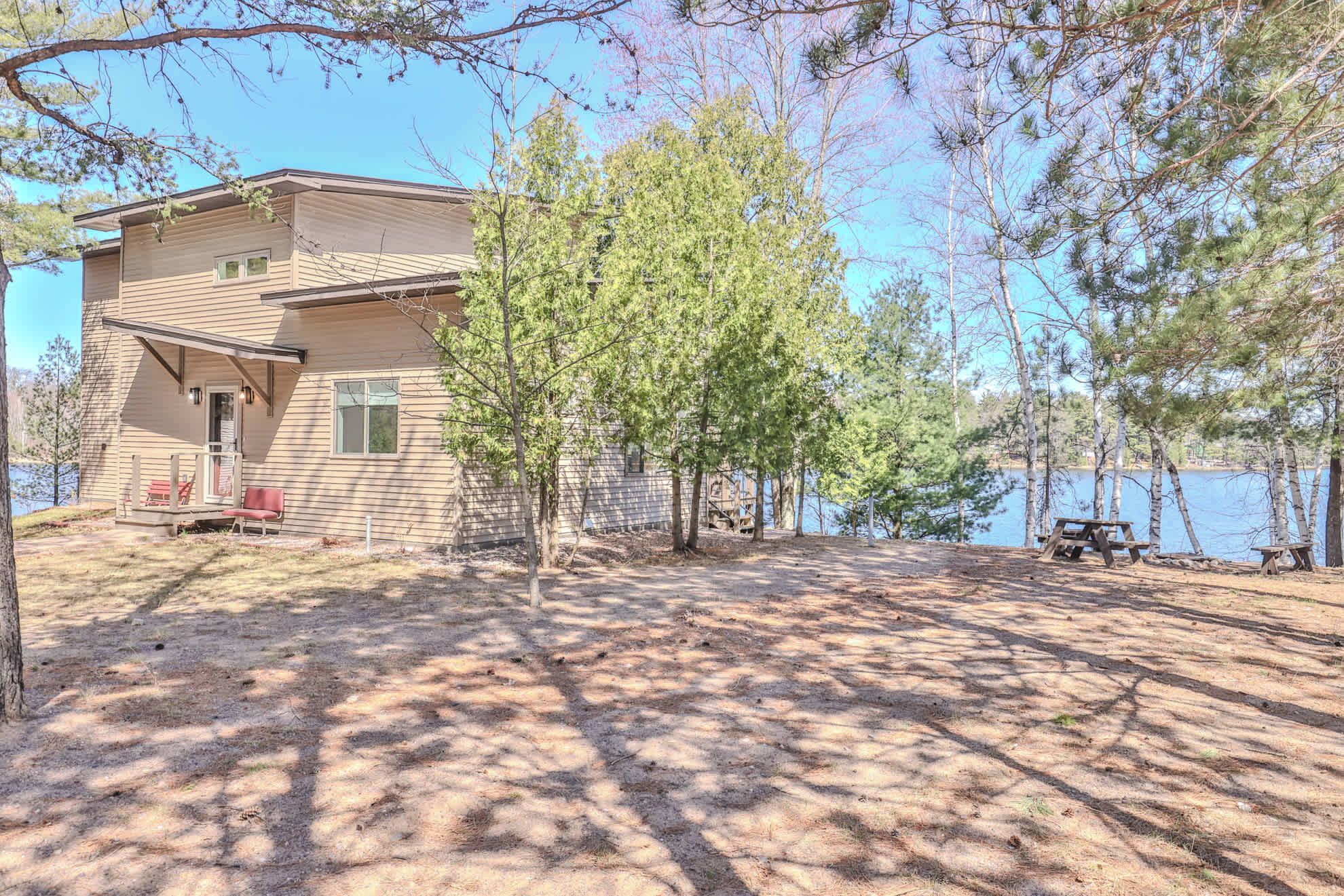 A two-story house with a porch and a covered patio area.