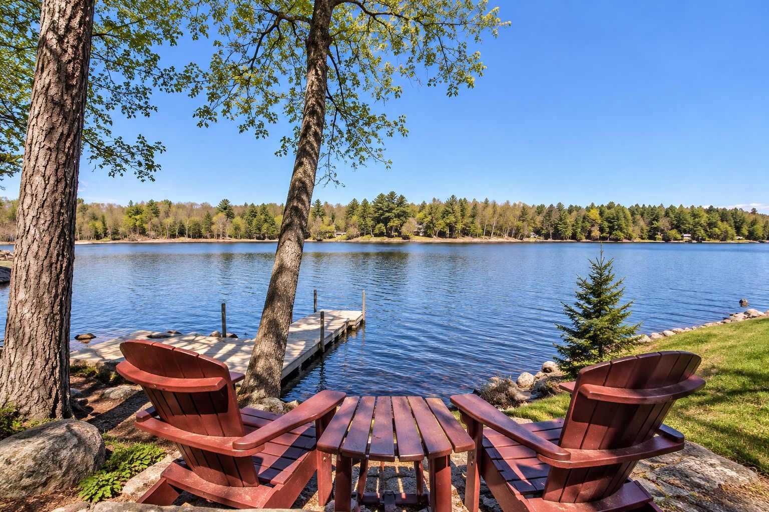 Un cadre idyllique au bord du lac, avec un quai, des chaises en bois et une table.