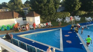 A swimming pool area with lounge chairs and a lifeguard station. - Freesia 3 Bedroom Modern Caravan Rockley Park, Poole Harbour, Dorset. Dogs free. (Poole)