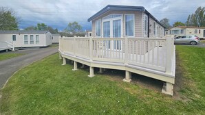 Une maison mobile de plain-pied dotée d’un balcon, d’une véranda et d’un garage.