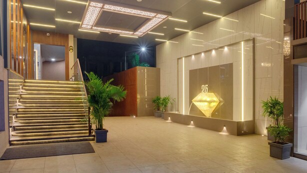 A modern building entrance with a prominent 'DIAMOND 26' sign, a staircase, and a large illuminated diamond sculpture. - Hotel Diamond 26 (Surat)