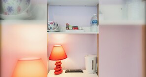 A small kitchenette with a red lamp, a kettle, and a remote control on a white countertop. - Chic stay by the Sea: close to Shops & Bars (Brighton and Hove)