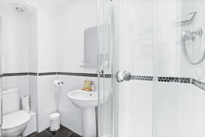 Un baño moderno con inodoro, lavabo y ducha.