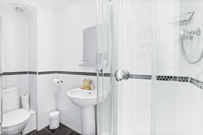A modern bathroom with a toilet, sink, and shower. - Chic stay by the Sea: close to Shops & Bars (Brighton and Hove)