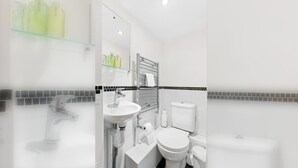 Une salle de bain moderne avec une douche à parois de verre, un lavabo blanc et des toilettes.