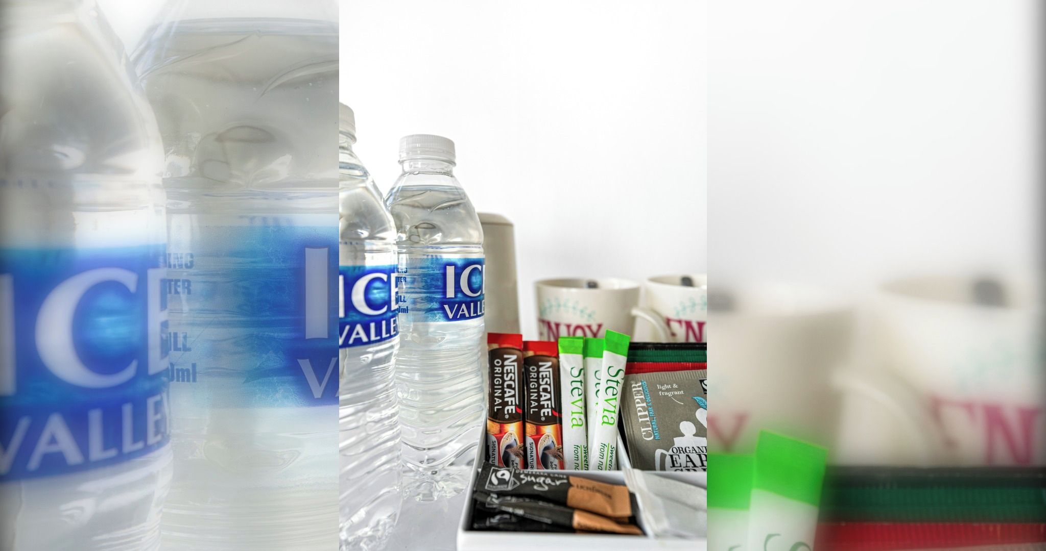 Verschillende flessen water en drankjes, waaronder zakjes Nescafe en Stevia.