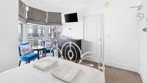A hotel room with a bed, a desk, a chair, and a TV. - Seaside Charm: Next to The Pier, Top Attractions (Brighton and Hove)