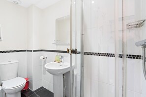 A bathroom with a toilet, sink, and shower. - Brighton Bliss: Cozy Stay by the Pier & Marina (Brighton and Hove)