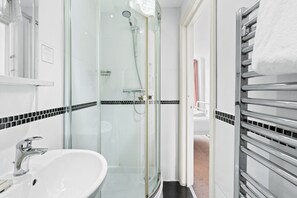A modern bathroom with a glass-enclosed shower, a white sink, and a towel rack. - Brighton Bliss: Cozy Stay by the Pier & Marina (Brighton and Hove)