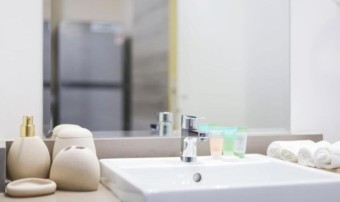 Ein Badezimmer mit Waschbecken, Spiegel und Pflegeprodukten.