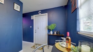A dining area with a table set for two, a potted plant, and a bottle of wine on the table. - Pet-friendly Fort Lauderdale Home: 8 Mi to Beach! (North Lauderdale)
