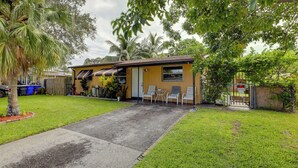A single-story house with a front yard, a small patio with two chairs, and a wooden fence. - Pet-friendly Fort Lauderdale Home: 8 Mi to Beach! (North Lauderdale)