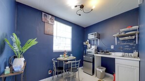 A compact kitchen with a microwave, toaster, and small refrigerator. There is a dining table with chairs and a potted plant. - Pet-friendly Fort Lauderdale Home: 8 Mi to Beach! (North Lauderdale)