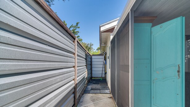 A narrow corridor with metal siding walls and a teal door. - 7 Mi to Dtwn: Studio w/ Screened Porch in Tampa (Tampa)