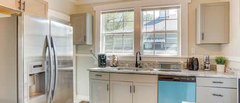 A modern kitchen with stainless steel appliances, a dishwasher, and a granite countertop.