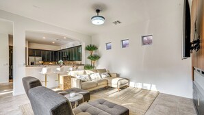 A modern living room with a sofa set, a coffee table, and a TV mounted on the wall. - Relax Poolside! Home 6 Mi to Camelback Ranch (Litchfield Park)