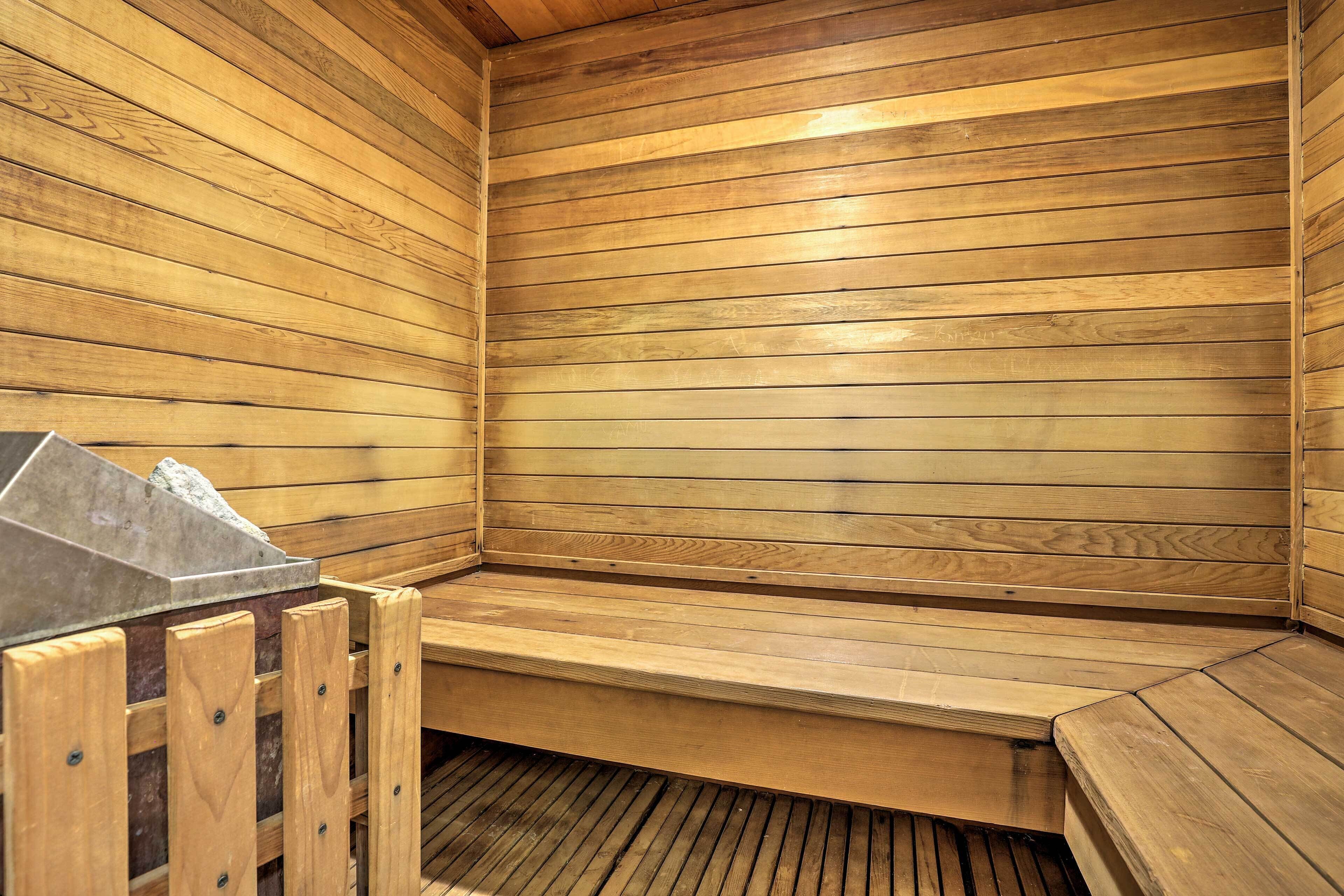 A wooden sauna with benches and a stone heating element.