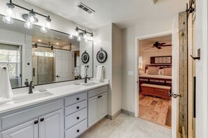A modern bathroom with a large vanity, double sink, and a walk-in shower. - Spacious Home w/ Swim Spa & Deck in Medford! (Medford)