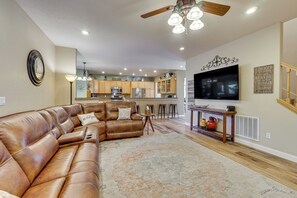 A spacious living room with a leather sectional sofa, a coffee table, and a large flat-screen TV. - Spacious Home w/ Swim Spa & Deck in Medford! (Medford)