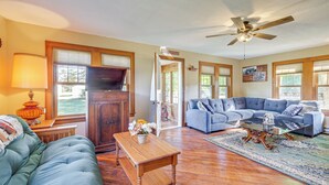 A spacious living room with a sectional sofa, a wooden coffee table, and a television. - Pet-friendly Farmhouse Near Lakes in Pellston (Pellston)