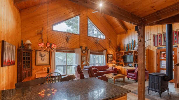 A spacious wooden cabin with a large kitchen area, a dining table, and a cozy living room with a fireplace. - Cozy Cabin | New Hot Tub! Near Shopping, Dining, Skiing, Golfing (Pagosa Springs)