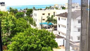 A view from a window overlooking a residential area with buildings, a pool, and a beach in the distance. - Lux Suites Kwamby Ocean paradise (Mombasa)