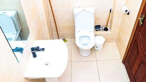 Une petite salle de bain comprenant des toilettes, un bidet et un lavabo.