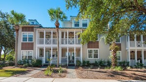 A multi-story residential building with a central courtyard, balconies, and a well-maintained garden. - Modern 2BR/2BA Condo Near Beach + Free Attraction Tickets! (Santa Rosa Beach)