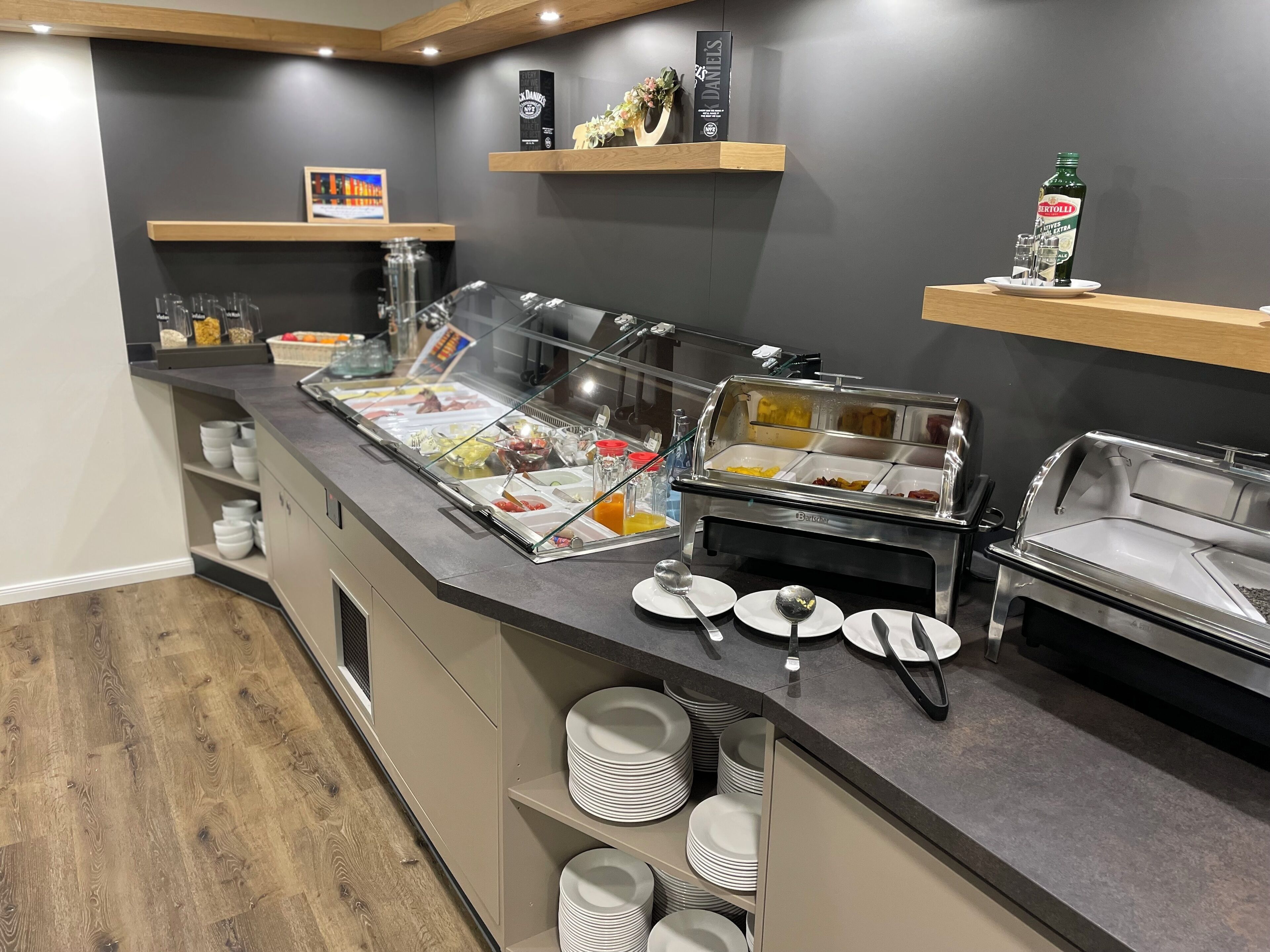 A buffet area with various food stations, including a beverage dispenser and a salad bar.