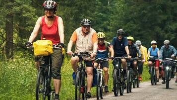 A group of cyclists on a paved road surrounded by greenery.