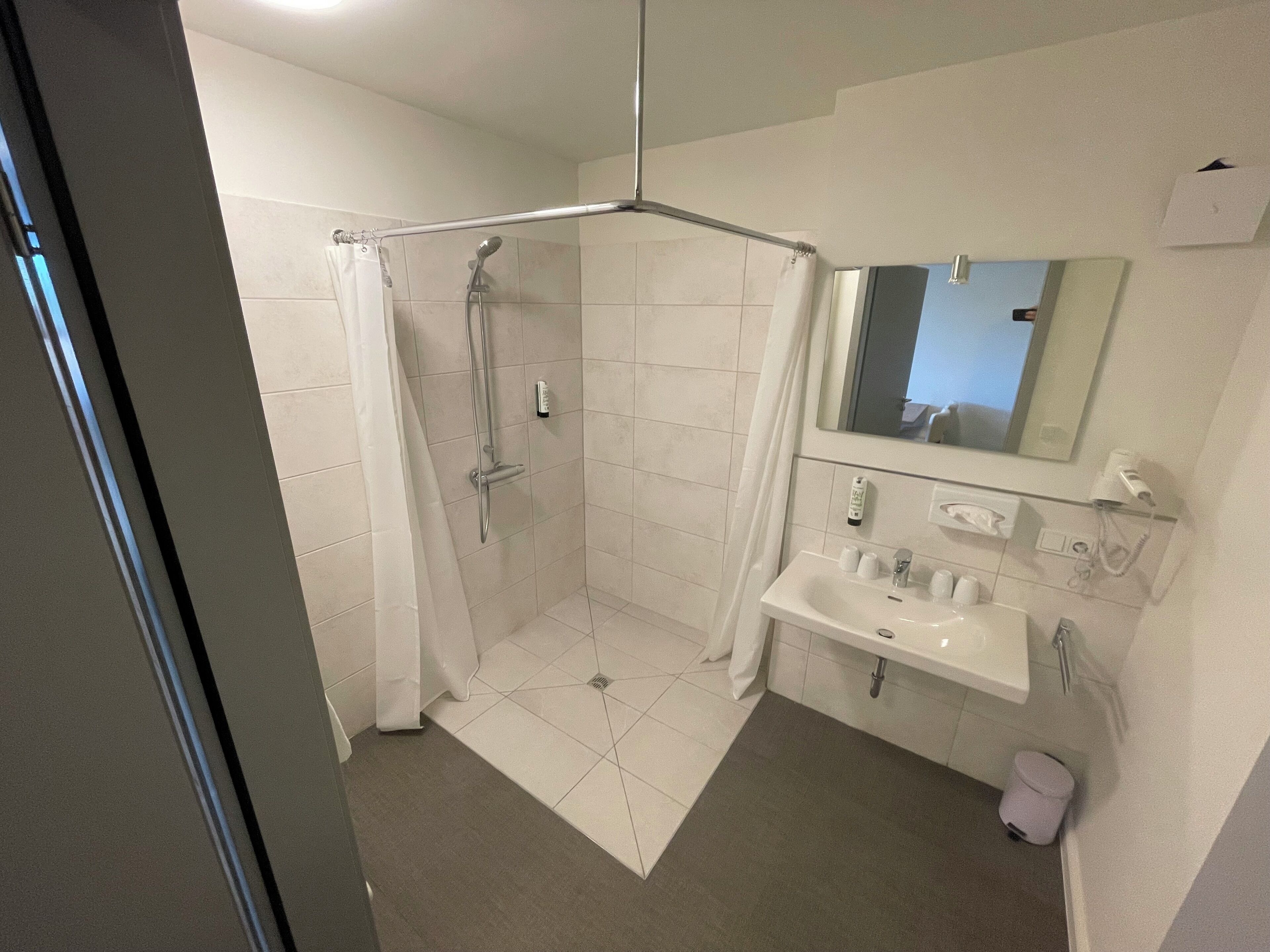 A modern bathroom with a shower, toilet, and sink.