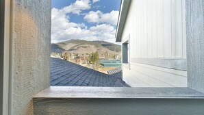 A view from a window overlooking a mountainous landscape with a tennis court visible in the distance. - La Riva Del Lago Condo: Downtown, Close to Everything! (Dillon)