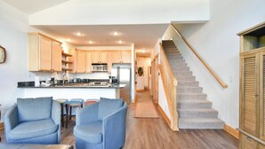 A modern kitchen with wooden cabinets, a central island, and a built-in microwave. - La Riva Del Lago Condo: Downtown, Close to Everything! (Dillon)