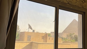 Una stanza con una parete in pietra e una finestra che dà su una piramide.