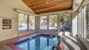 An indoor swimming pool with clear views of the outside, a wooden ceiling, and a safety sign on the wall. - 1147 Flying Dutchman 1 Bedroom Condo (Keystone)