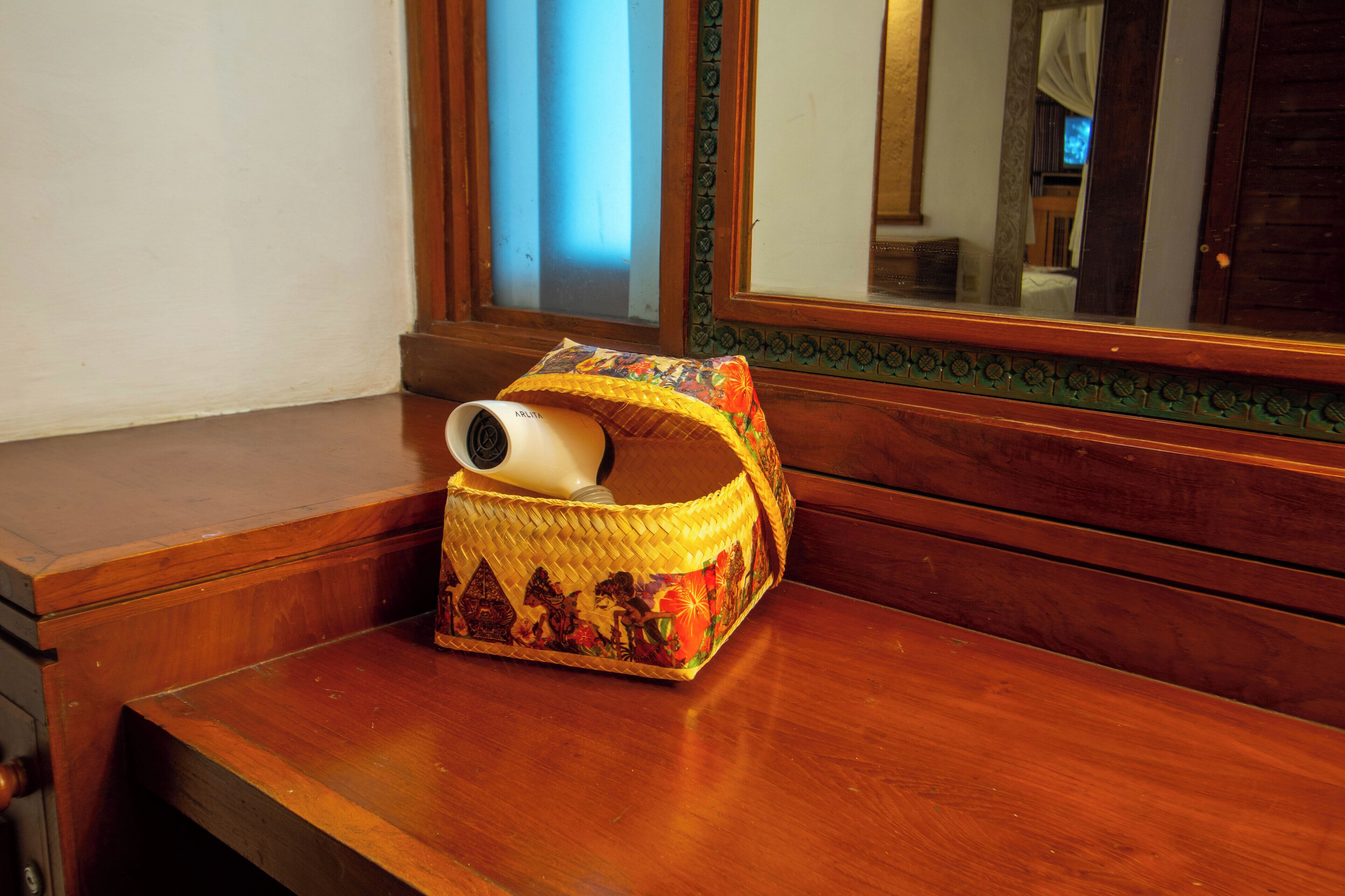 A wooden bench with a woven basket containing a camera.